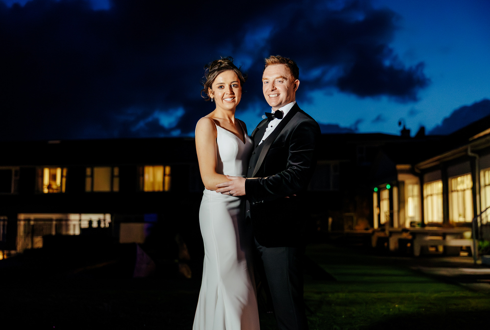 Laura and Simon brave the elements for an outdoor photo on a wild and windy wedding evening at the Connemera Coast Hotel.